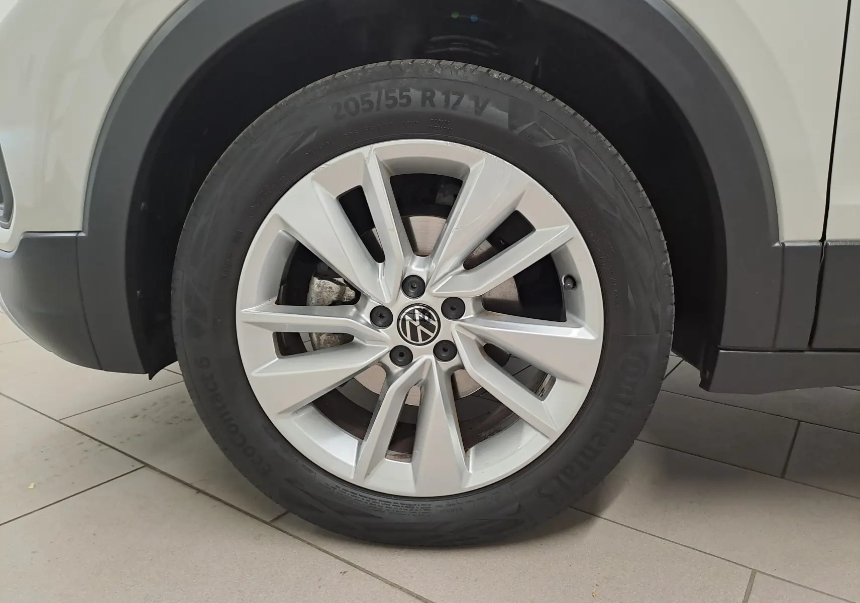 Gros plan sur la roue avant droite avec jante argentée du Volkswagen T-Cross Gris Ascot 2024.