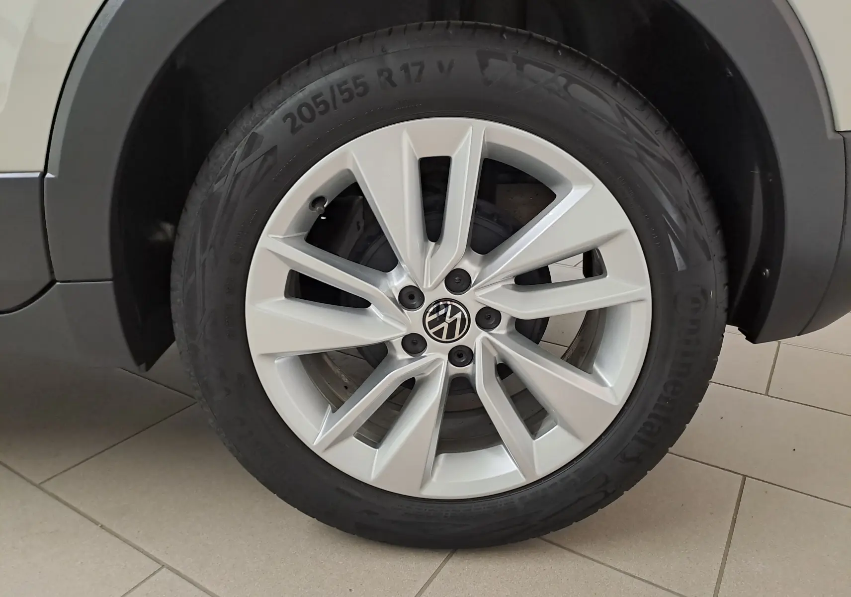 Gros plan sur la roue avant droite du Volkswagen T-Cross 2024 gris Ascot avec jante alliage et pneu Continental.
