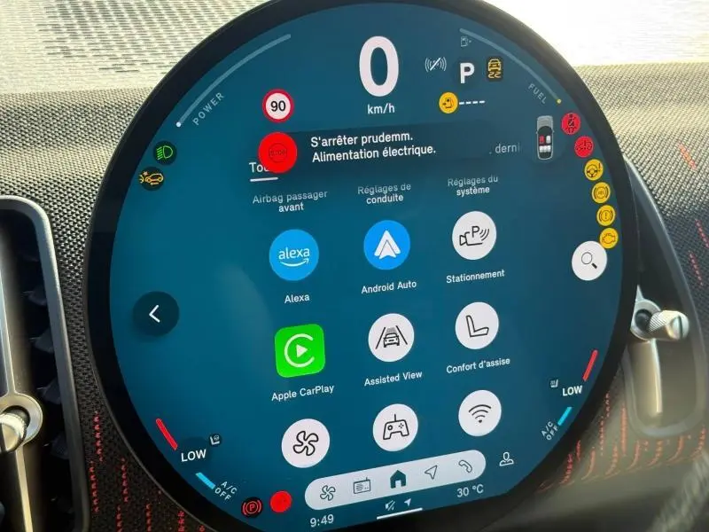 Affichage numérique circulaire du tableau de bord de la MINI Countryman argentée, montrant les options connectées et alertes de conduite.