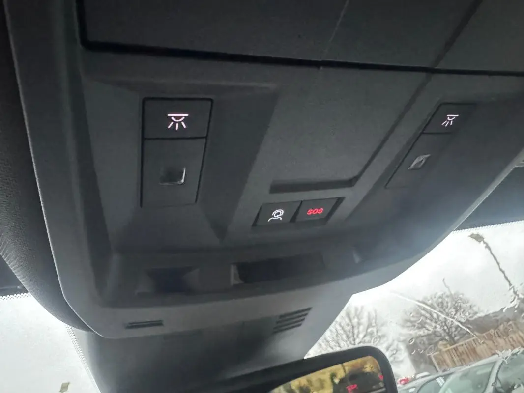 Vue intérieure du plafond avec commandes d'éclairage et bouton SOS du Peugeot 3008 Hybrid 145 e-DCS6 Allure noir 2025.