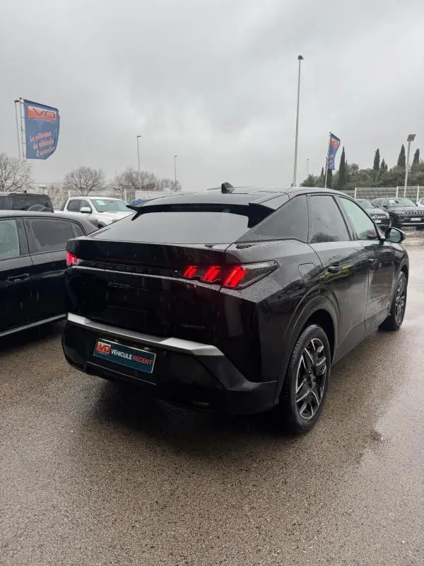 Vue 3/4 arrière droite d’un Peugeot 3008 Hybrid 145 noir avec feux arrière allumés et jantes alliage 19 pouces.