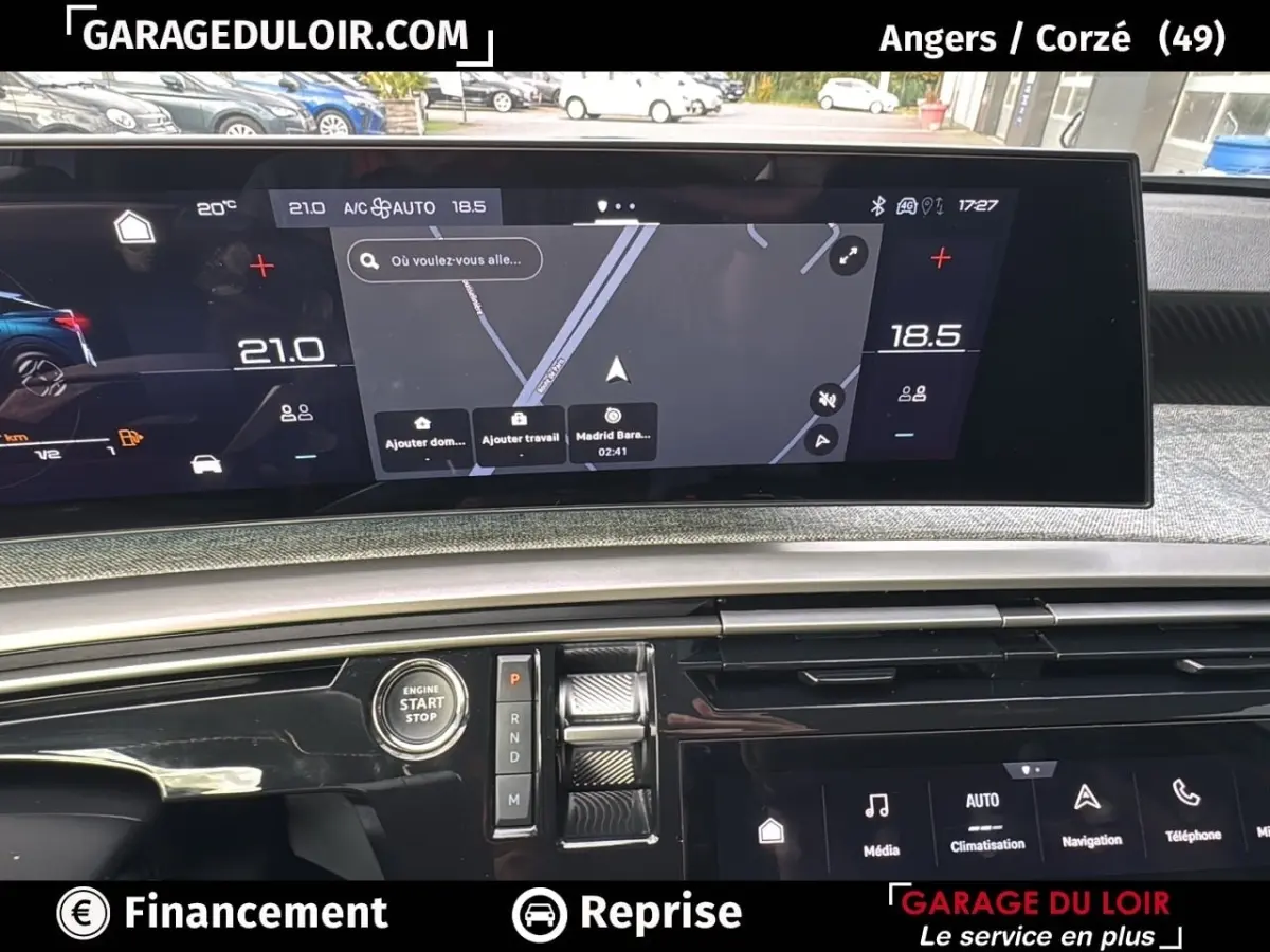 Vue rapprochée de l’intérieur du Peugeot 3008 2024 hybride, montrant l’écran tactile central et les commandes de climatisation.