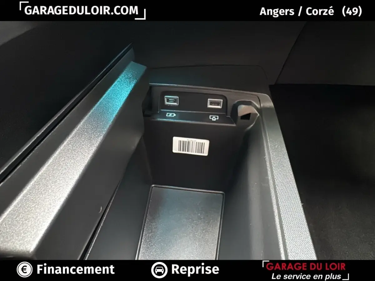 Gros plan sur la console centrale intérieure du Peugeot 3008 gris clair, montrant deux ports USB et un espace de rangement.