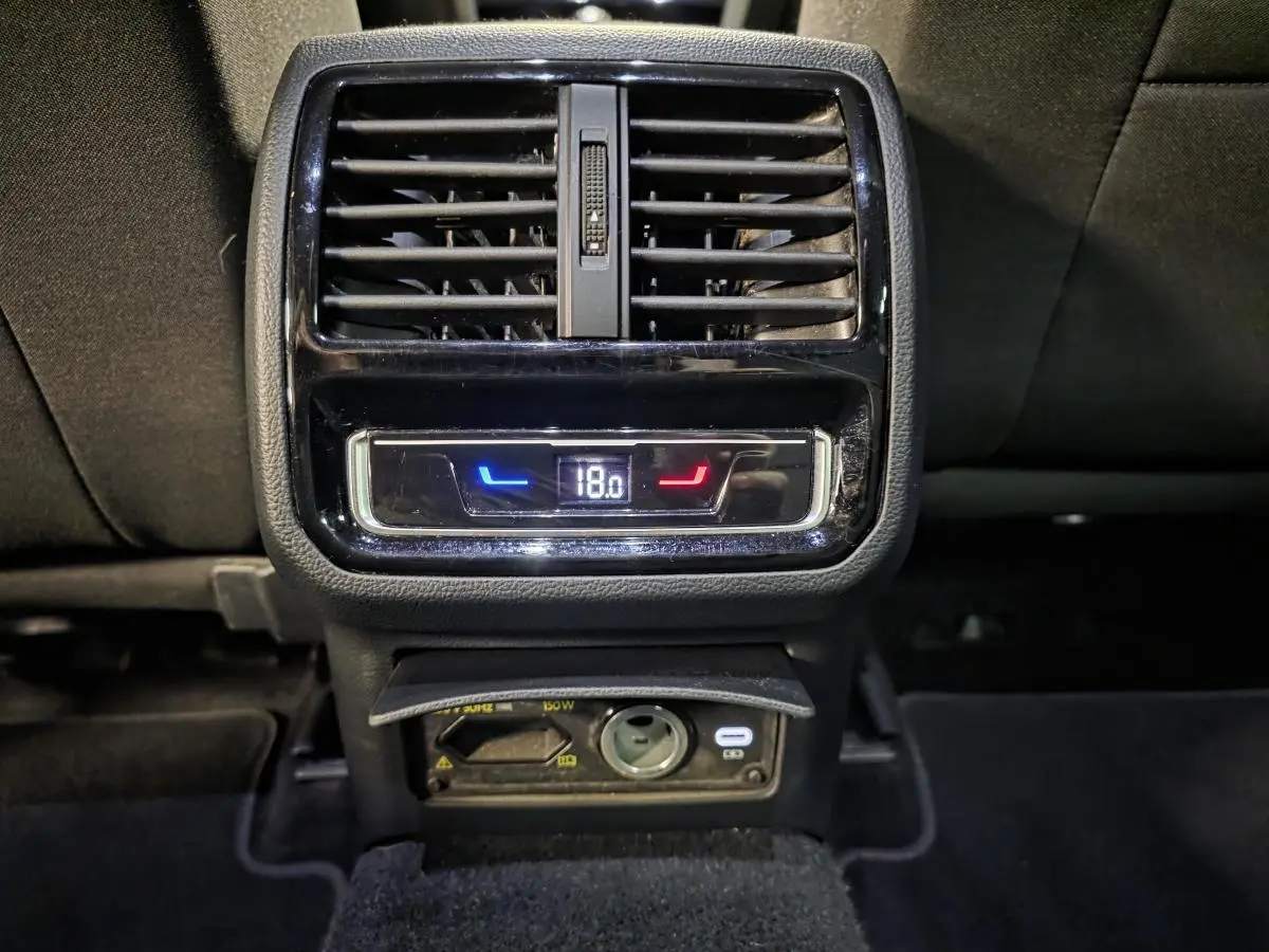 Détail de la console arrière noire de la Volkswagen Passat SW 2023 avec ventilation et réglage de température à 18°C.