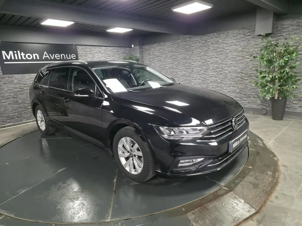 Volkswagen Passat SW noire vue en 3/4 avant droit, avec jantes alliage et vitres teintées en showroom.