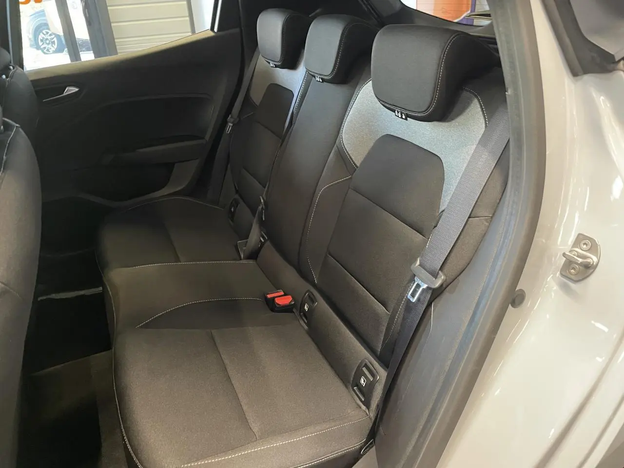 Vue intérieure côté arrière droit sur la banquette tissu gris avec appuis-têtes de la Renault Clio 1.5 Blue dCi 2025.