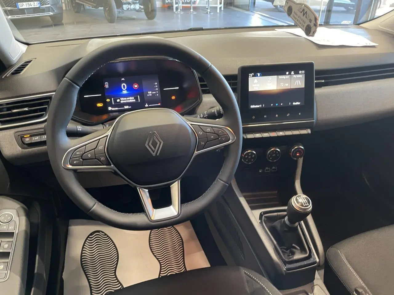 Vue intérieure du poste de conduite de la Renault Clio 1.5 Blue dCi 2025 avec volant multifonction et boîte manuelle.