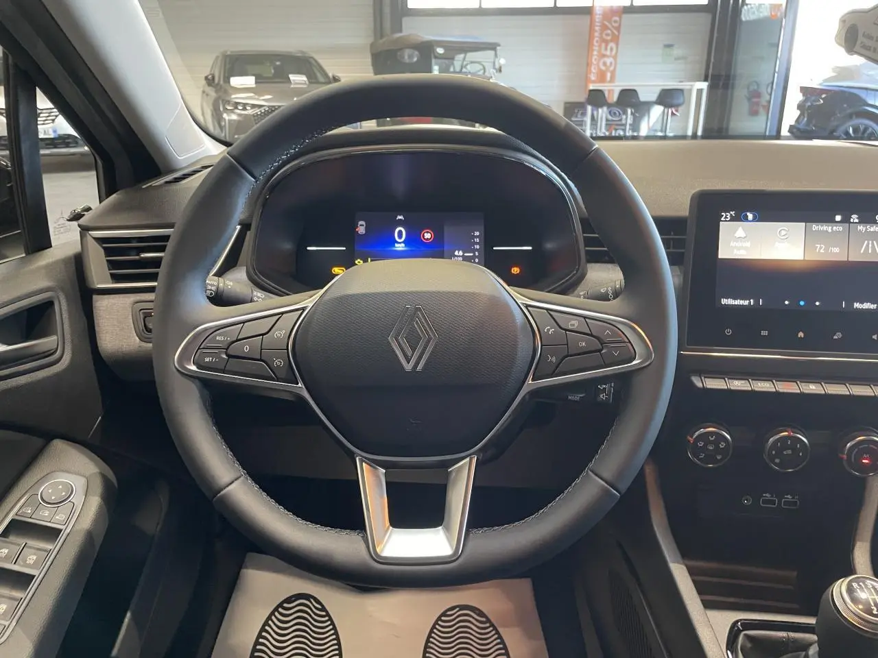 Vue intérieure centrée sur le volant multifonction Renault Clio 1.5 Blue dCi gris Rafale avec tableau de bord numérique.