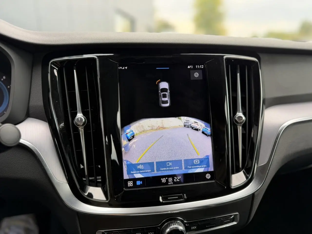 Écran tactile central de la Volvo S60 2024 affichant la caméra de recul et les radars de stationnement.