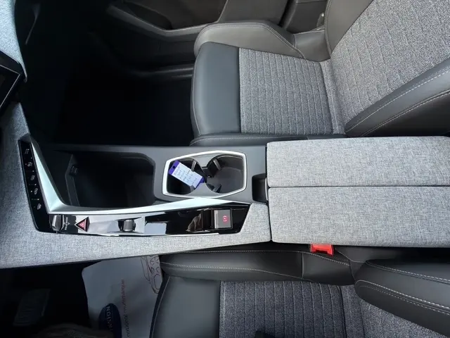 Vue plongeante sur la console centrale et les sièges avant gris et noir du Peugeot 3008 1.2 Hybrid 145 Allure 2026.