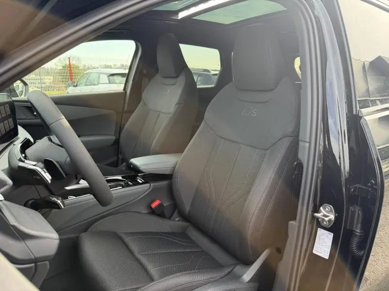 Vue intérieure côté conducteur de l'Audi Q3 2.0 TDI S line 2026 avec sièges noirs embossés S et toit ouvrant.