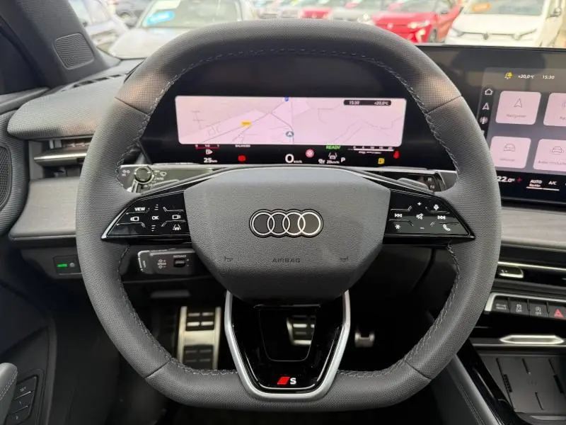 Vue centrée du volant cuir noir avec logo Audi et affichage numérique du tableau de bord du Q3 2.0 TDI S line 2026.