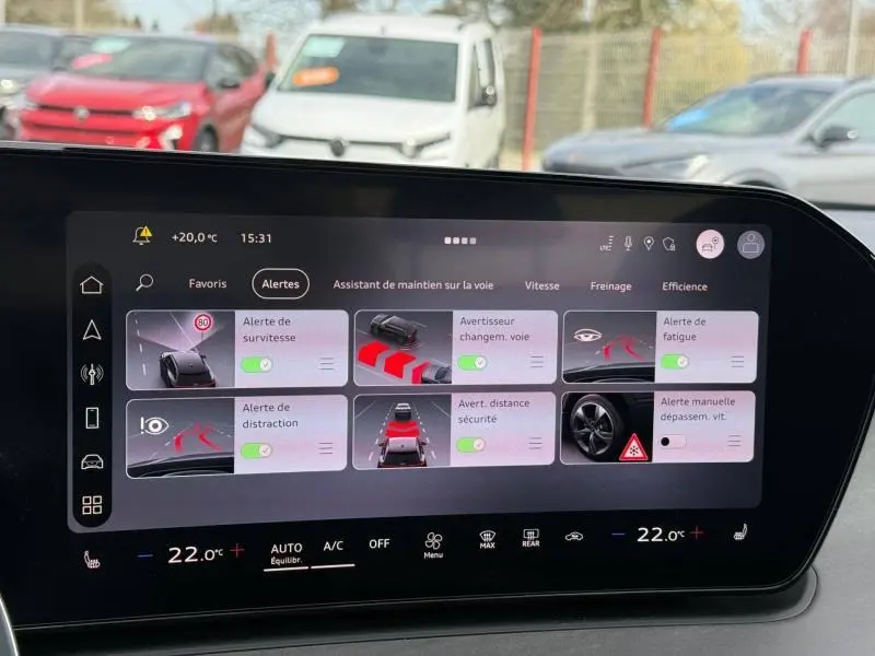 Tableau de bord numérique d'Audi Q3 2026 montrant les alertes de conduite avec interface moderne et fond noir.