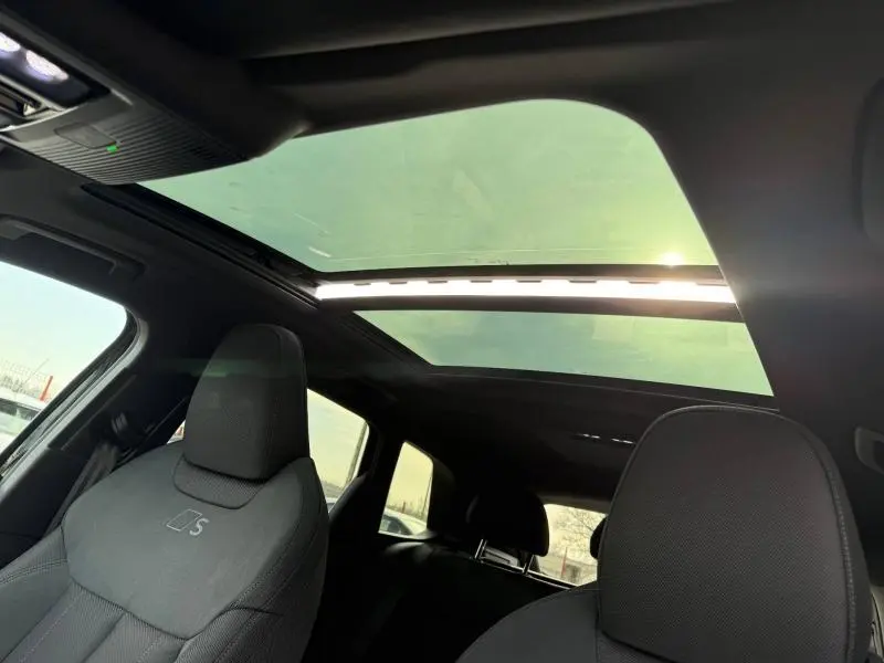 Intérieur de l'Audi Q3 2026 S line vu côté conducteur, avec toit panoramique et sièges noirs S line.