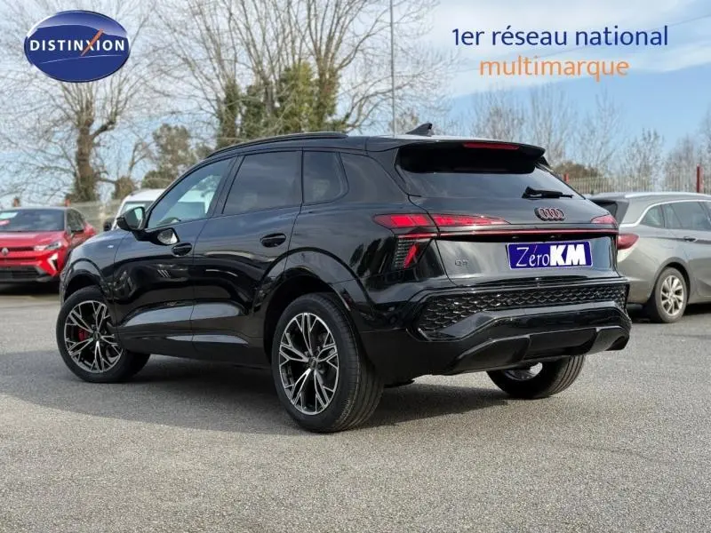 Audi Q3 2026 noir Mythique métallisé, vue 3/4 arrière côté gauche, avec jantes S line et feux LED distinctifs.