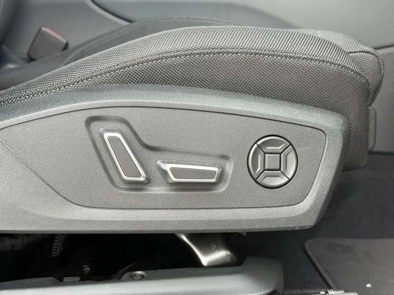 Détail des commandes de réglage électrique du siège conducteur sur Audi Q3 2.0 TDI 150ch S line noir métallisé, intérieur tissu.