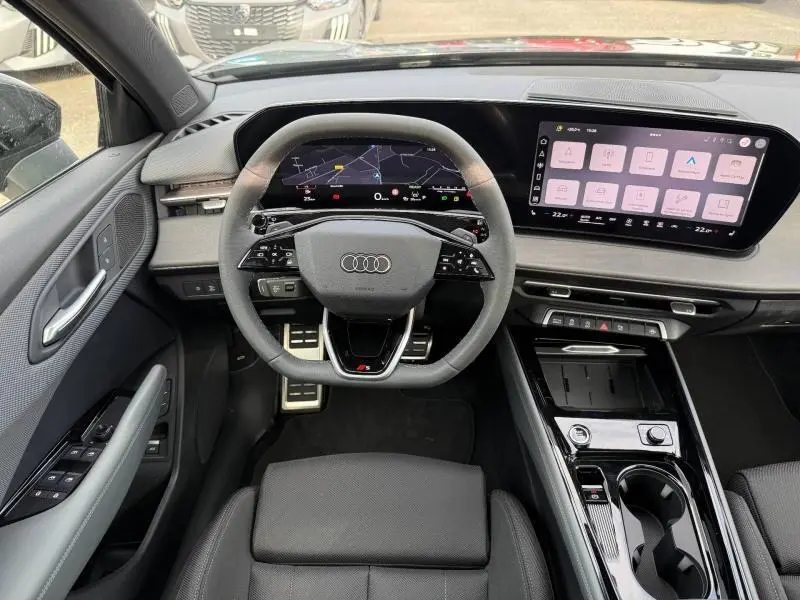 Vue intérieure de face du tableau de bord et volant de l'Audi Q3 2.0 TDI 150ch S line 2026 avec écran digital large et finitions noires.