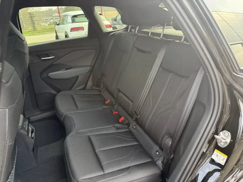 Vue intérieure côté droit des sièges arrière en tissu noir du SUV Audi Q3 2.0 TDI 150ch S line 2026, porte ouverte.