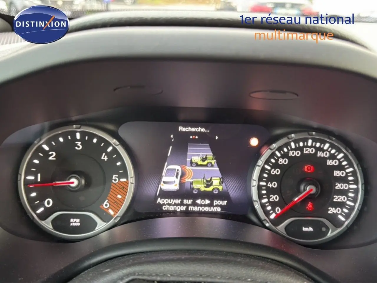 Tableau de bord du Jeep Renegade noir 2022 montrant compte-tours, vitesse et écran d'aide au stationnement.