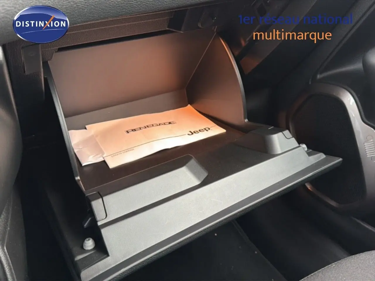 Gros plan sur la boîte à gants ouverte du Jeep Renegade 2022 avec manuel visible, intérieur noir.