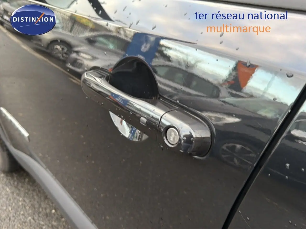 Poignée de porte noire brillante du côté gauche d'un Jeep Renegade 2022 Diesel avec reflets d'autres véhicules.