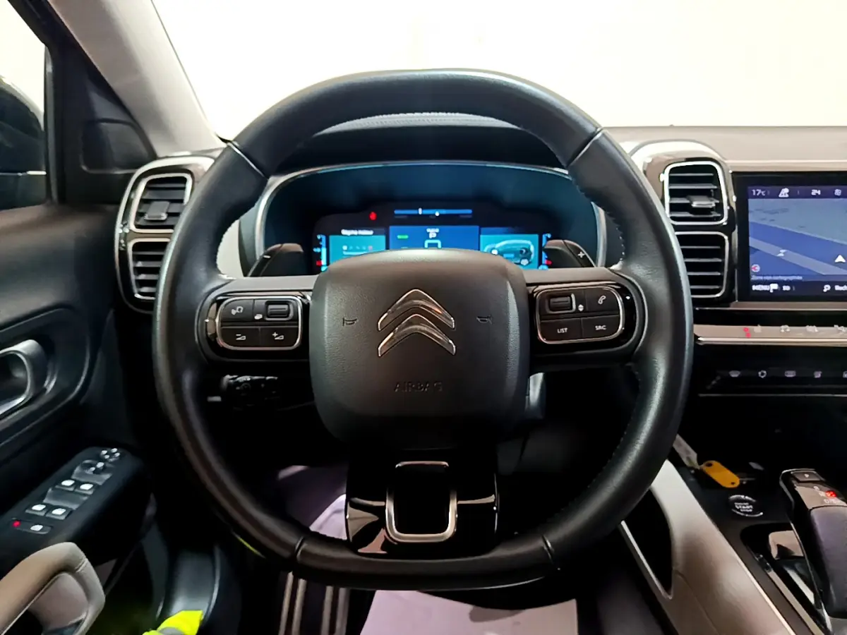Vue intérieure centrée sur le volant cuir noir et le tableau de bord numérique du Citroën C5 Aircross Hybrid 225 ë-EAT8 Shine.