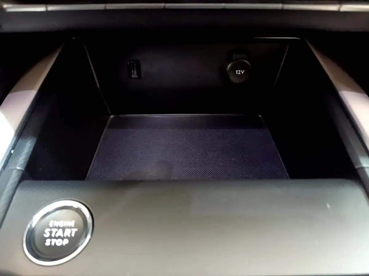 Détail du rangement central noir avec prise 12V et bouton démarrage sur le Citroën C5 Aircross Hybrid 225 ë-EAT8 Shine.