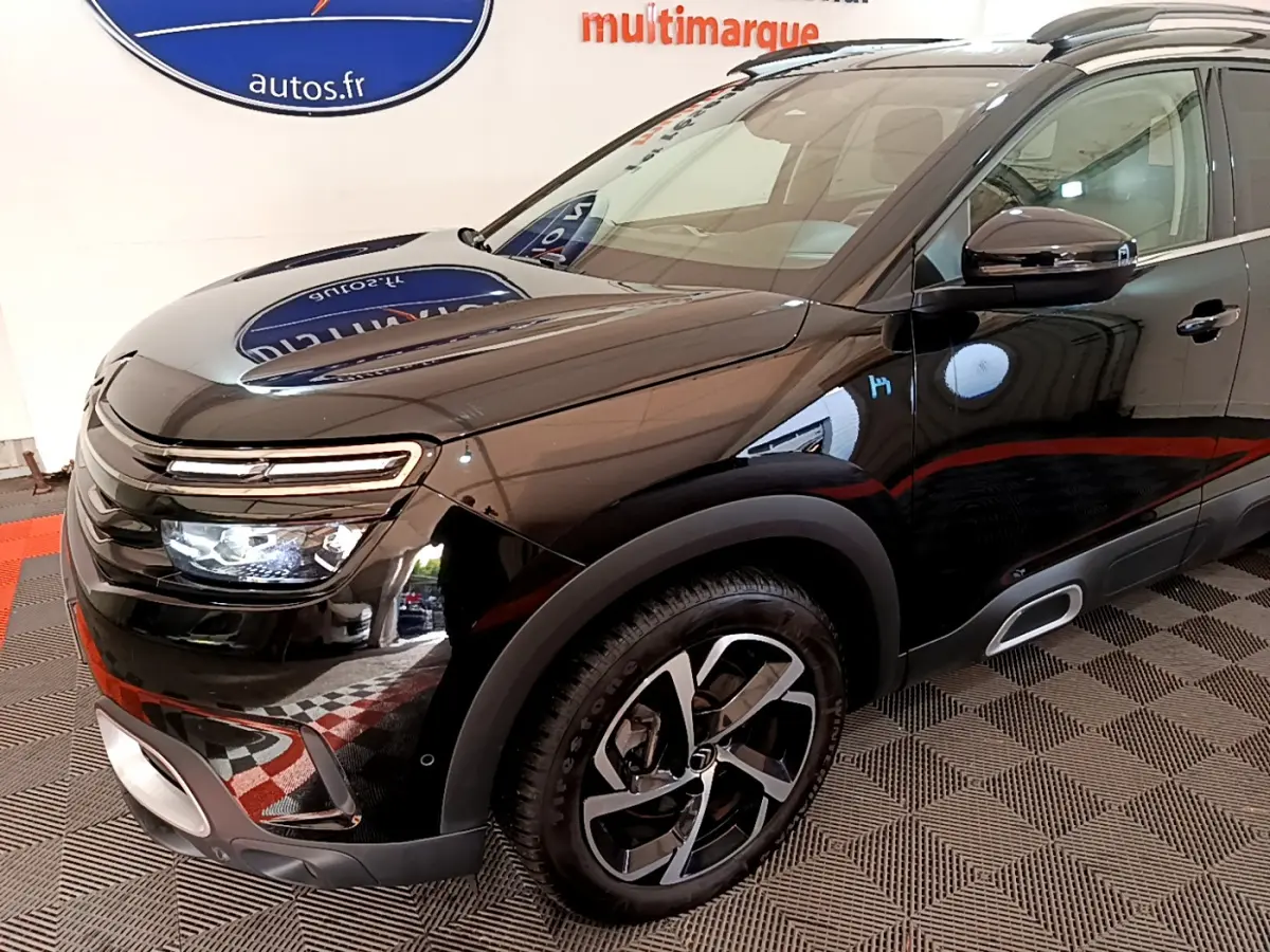 Vue 3/4 avant droit du Citroën C5 Aircross Hybrid 225 noir brillant avec jantes alliage et feux LED allumés.