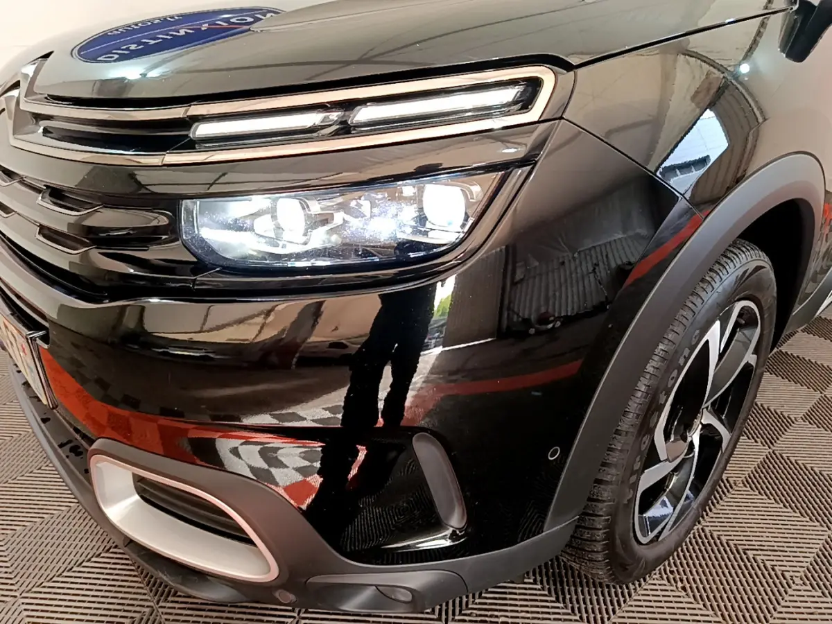 Gros plan sur l'avant droit noir brillant du Citroën C5 Aircross Hybrid avec phares LED et jante stylisée.