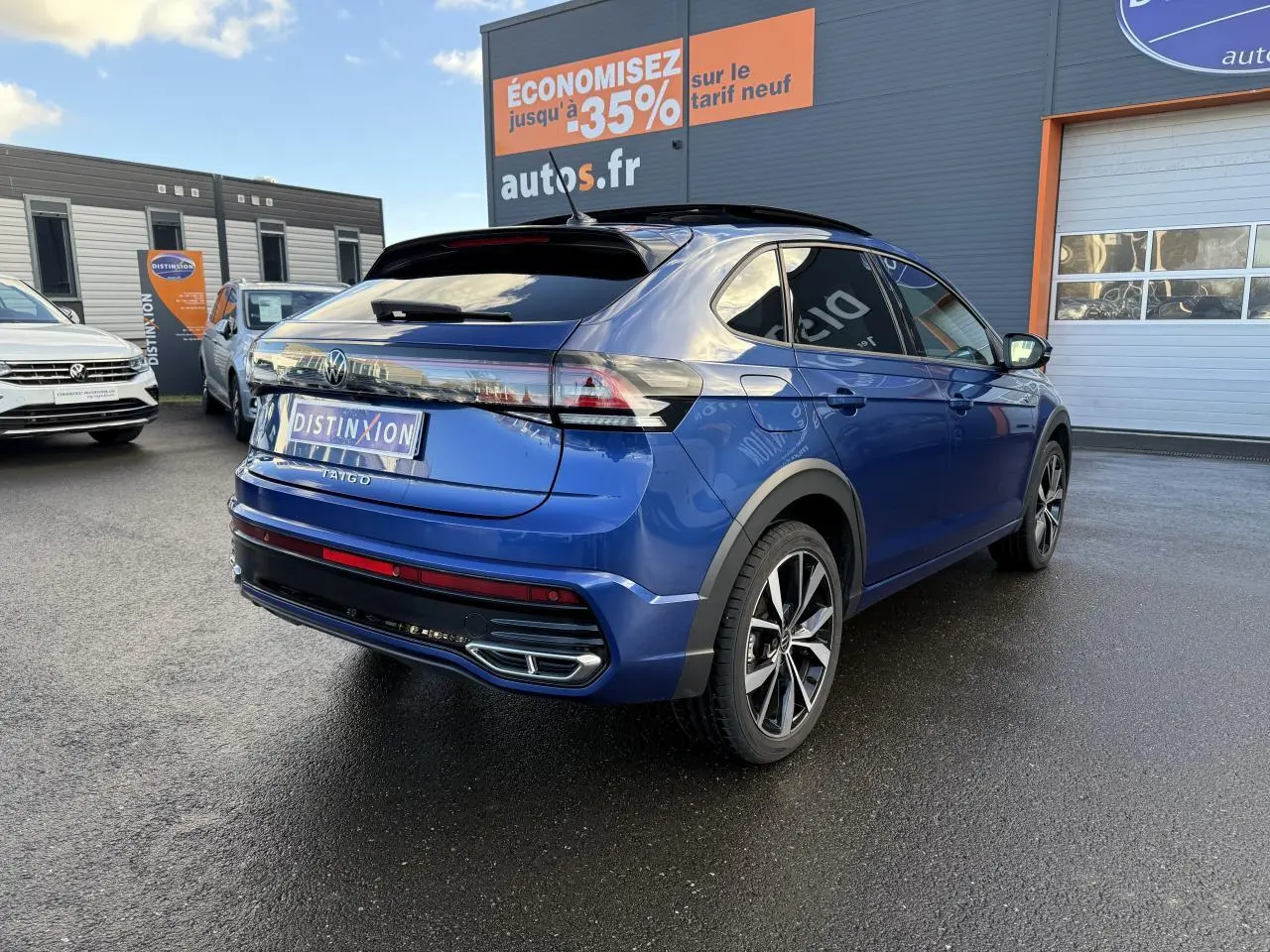 Volkswagen Taigo bleu récif métallisé en 3/4 arrière droit avec jantes noires brillantes et toit ouvrant en verre