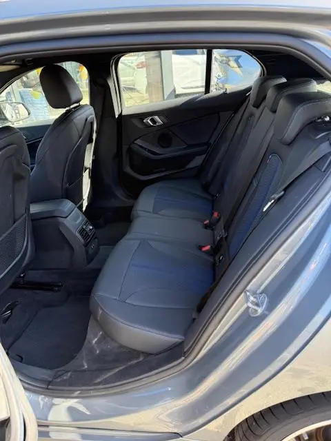 Vue intérieure côté droit de la banquette arrière en cuir gris foncé de la BMW Série 1 118d Edition Sport 2024.