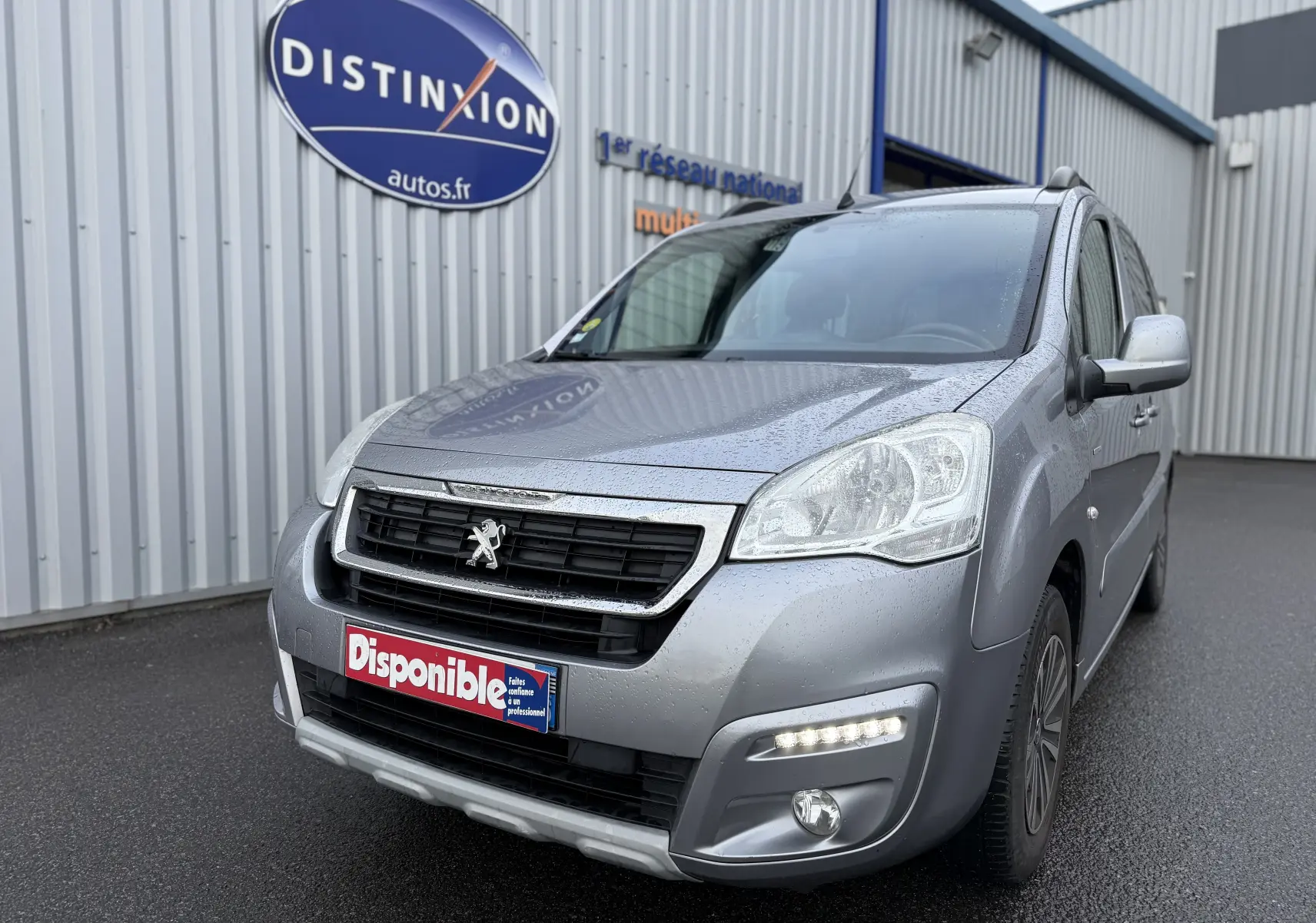 Vue 3/4 avant droit d'un Peugeot Partner Tepee gris 2018 avec feux LED diurnes et plaque "Disponible" visible.