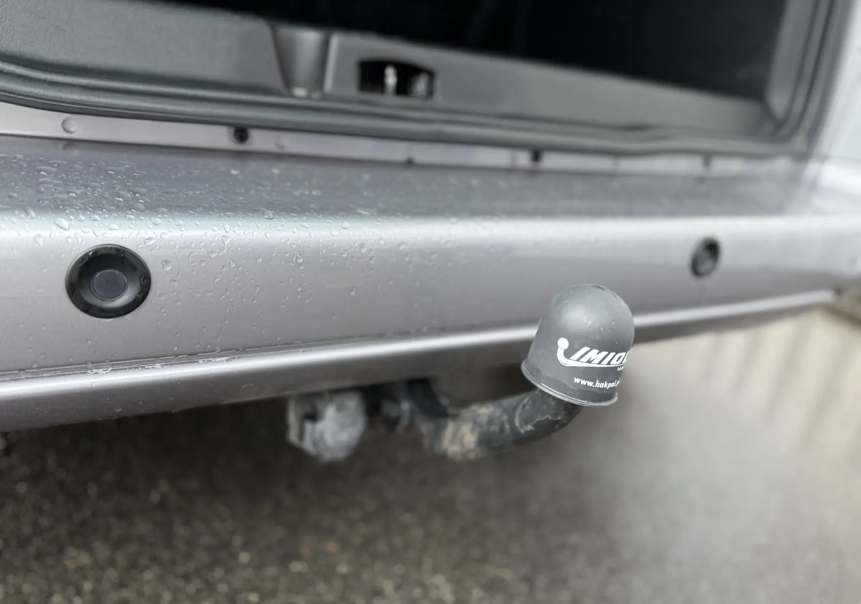 Gros plan sur l'attelage de remorque gris du Peugeot Partner Tepee 2018, avec capuchon de protection noir visible.