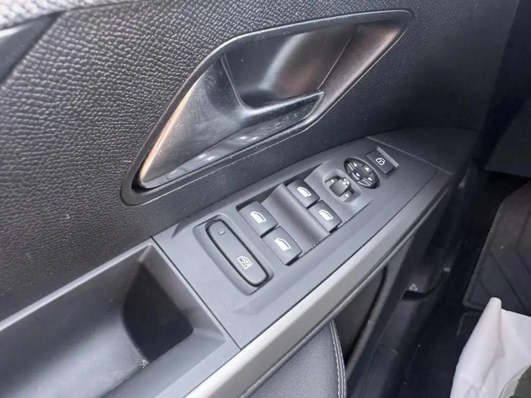 Gros plan sur la commande des vitres et rétroviseurs côté gauche intérieur noir du Peugeot 3008 Hybrid 145 Allure 2025.