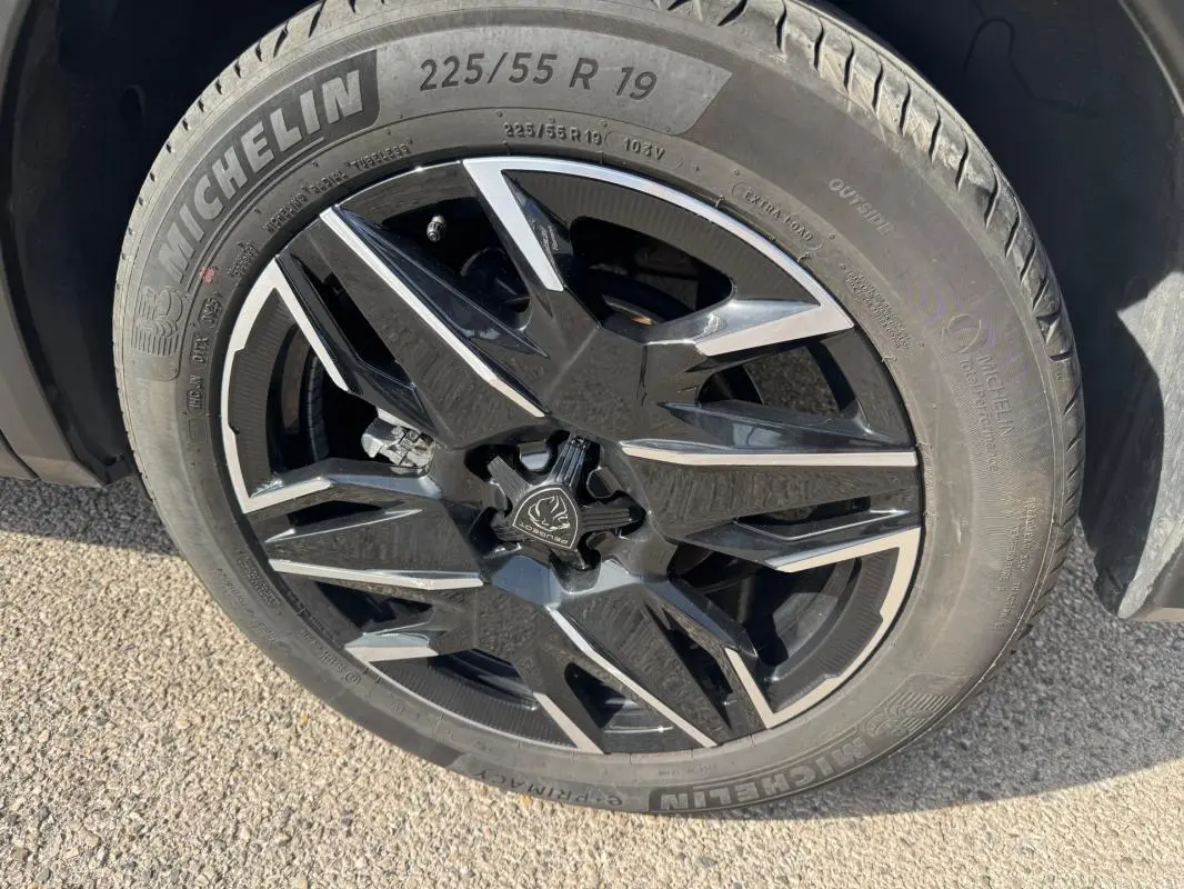 Gros plan sur la jante alliage noire et argentée de 19 pouces du Peugeot 3008 Hybrid 145 e-DCS6 Allure noir.