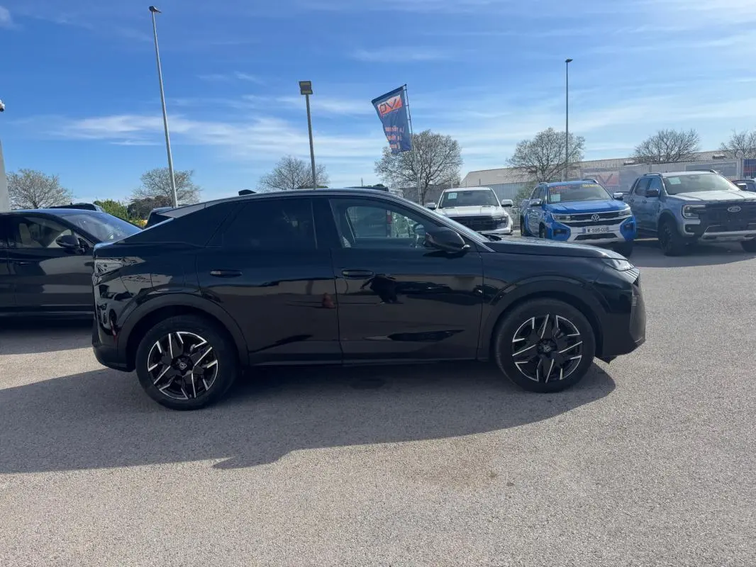 Profil côté gauche du Peugeot 3008 Hybrid noir 2025 avec jantes alliage 19 pouces, stationné en extérieur sous ciel bleu.