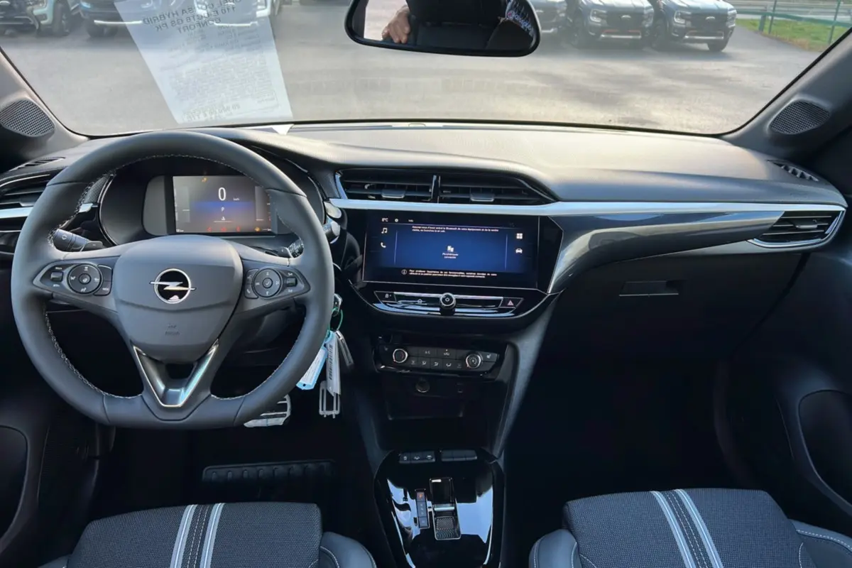 Vue intérieure avant de l’Opel Corsa Hybrid gris kristall, avec volant cuir multifonctions et écran tactile central 10 pouces.