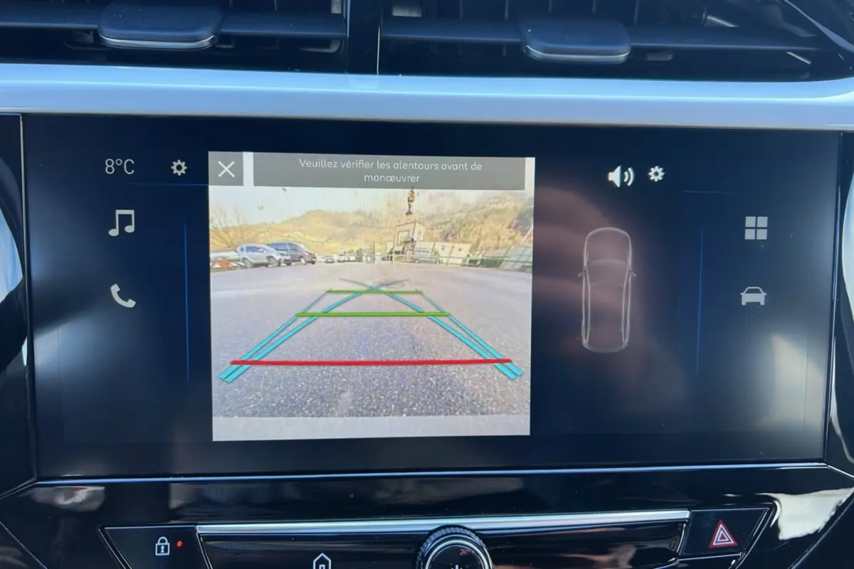 Écran tactile intérieur montrant la caméra de recul avec lignes de guidage dans une Opel Corsa Hybrid gris kristall.