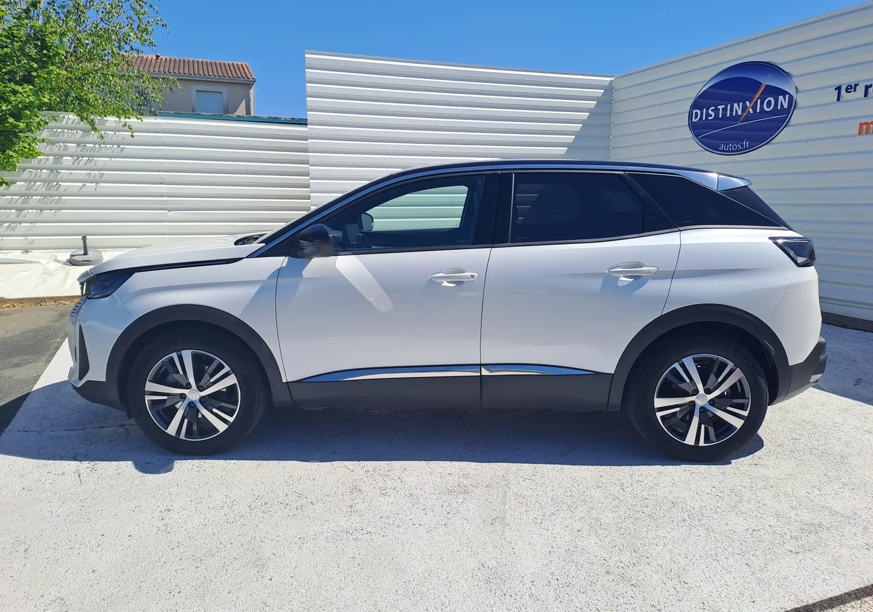 Vue de profil côté gauche d’un Peugeot 3008 blanc nacré avec toit noir, jantes alliage et vitres teintées.