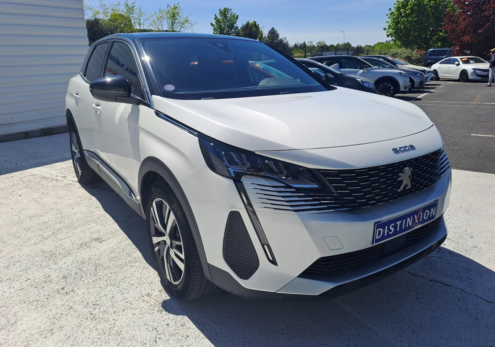 Peugeot 3008 blanc nacré avec toit noir, vue 3/4 avant droit, mettant en valeur sa calandre et ses optiques LED distinctives.