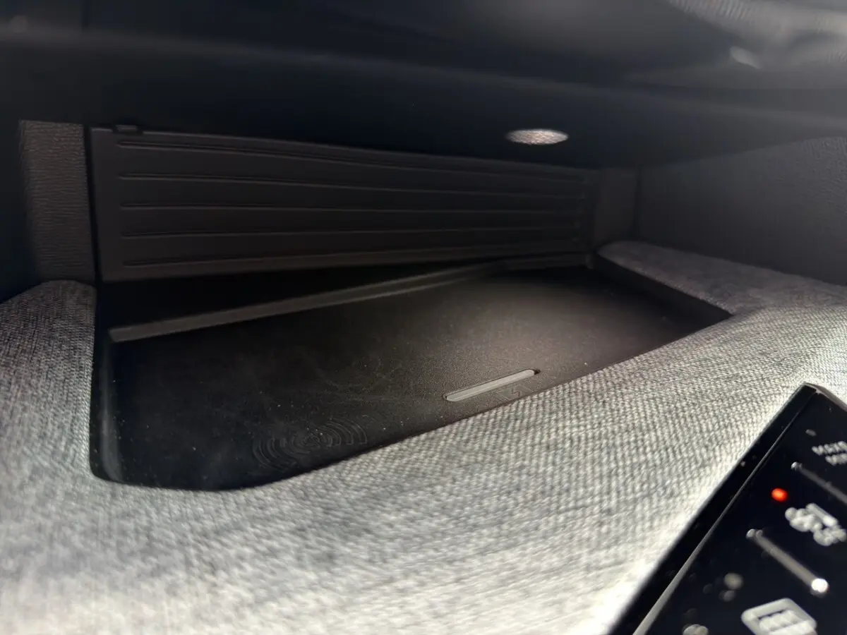 Détail intérieur du chargeur sans fil dans la console centrale du Peugeot 3008 noir 2026.