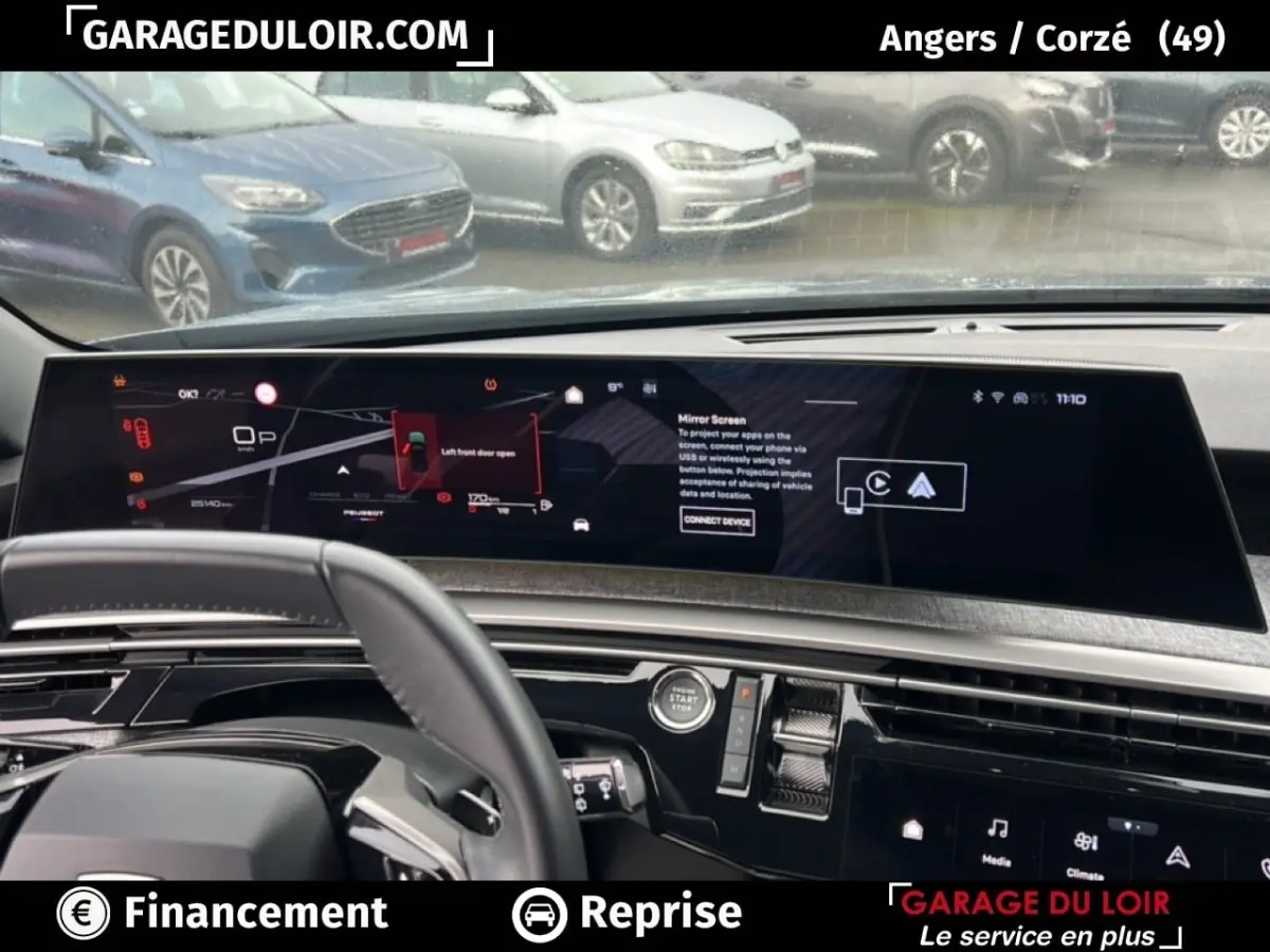 Tableau de bord numérique large du Peugeot 5008 bleu, vue intérieure avant avec volant partiellement visible.