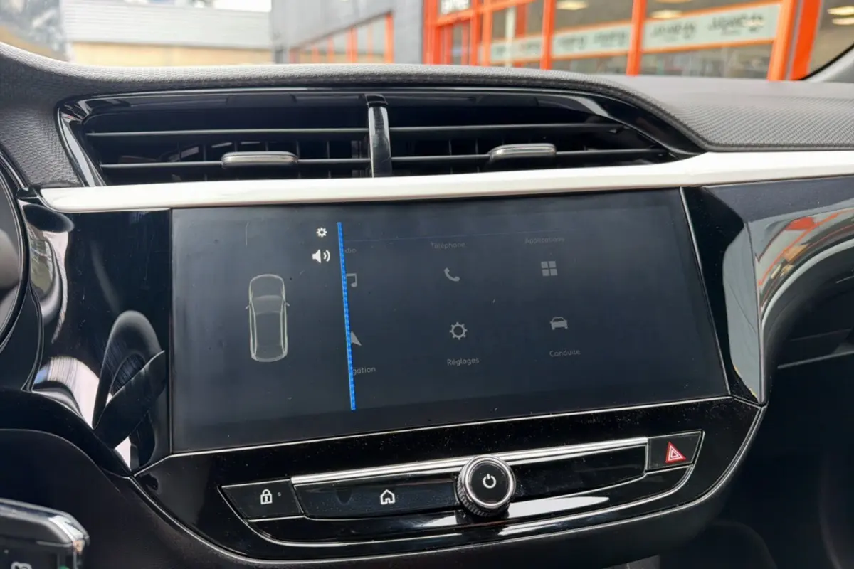 Vue rapprochée de l’écran tactile central noir brillant de l’Opel Corsa Hybrid 2026, avec commandes visibles.