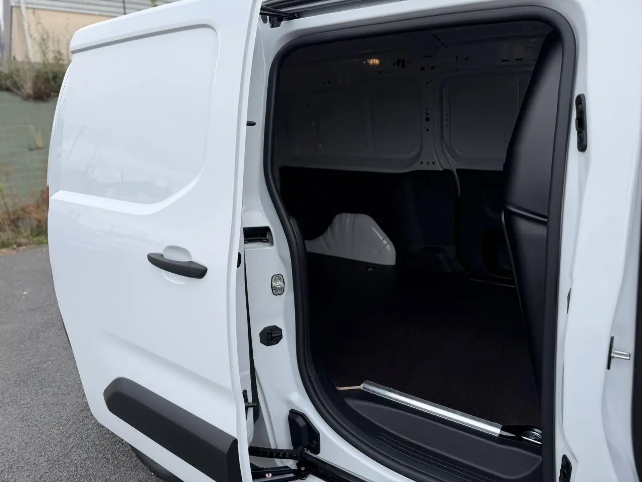 Vue de profil côté droit du Citroën Berlingo blanc Icy avec porte latérale coulissante ouverte montrant l’espace de chargement.