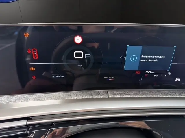 Affichage numérique du combiné d'instruments du Peugeot 3008 hybride 2026 avec message d'arrêt et indicateurs lumineux.