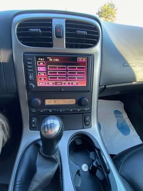 Intérieur de la Chevrolet Corvette C6 Targa 2005, vue sur la console centrale avec levier de vitesse manuel et écran radio tactile.