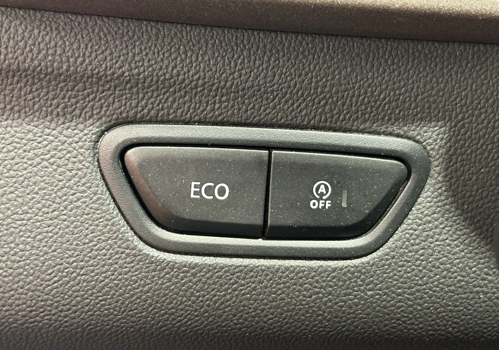 Gros plan sur les boutons ECO et désactivation du start-stop dans l'habitacle du Renault Kadjar gris 2015.