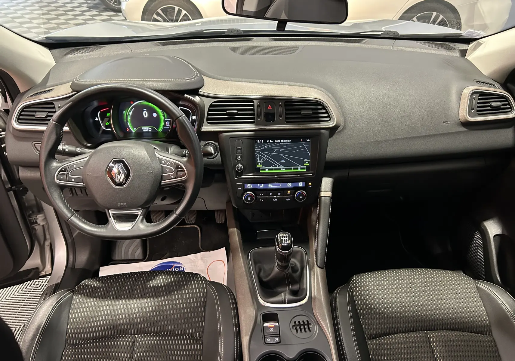 Intérieur Renault Kadjar gris 2015 vu de face, tableau de bord avec écran tactile et volant multifonction.