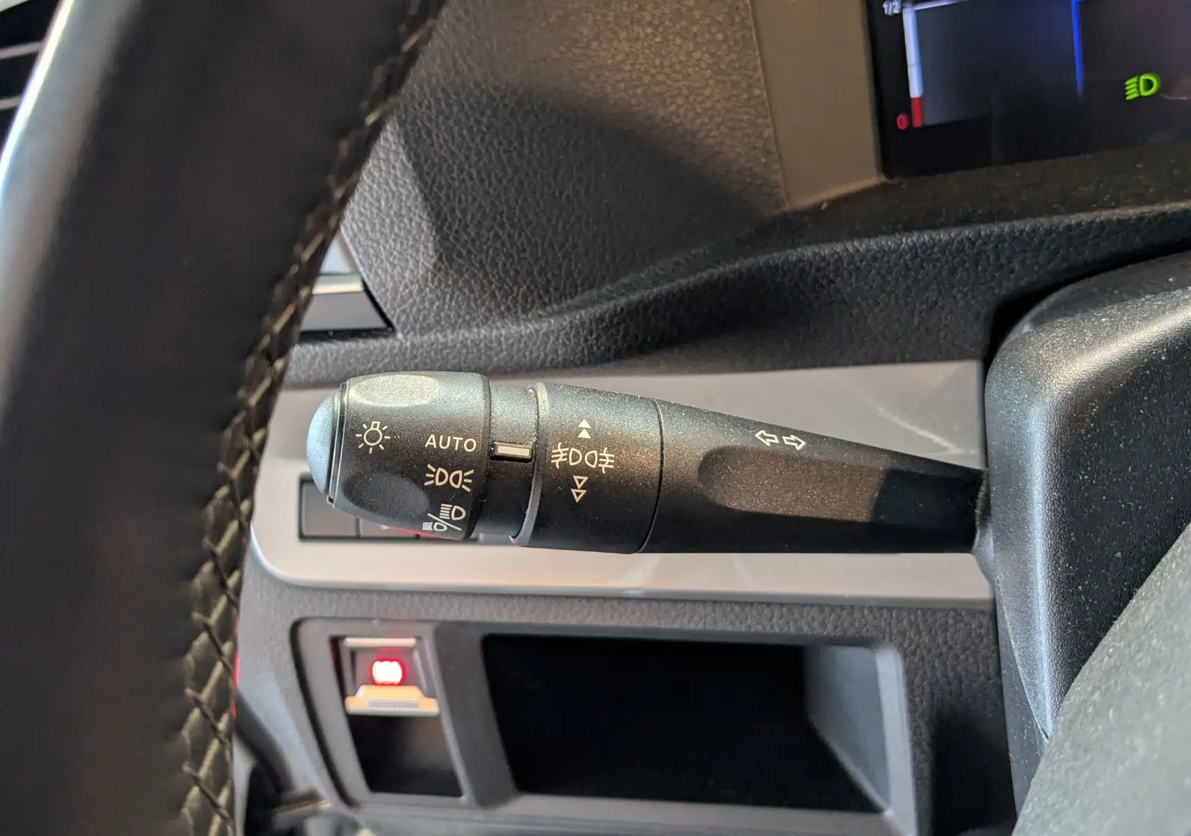 Gros plan sur la manette de commande des phares et clignotants dans l'habitacle du fourgon Opel Vivaro blanc.