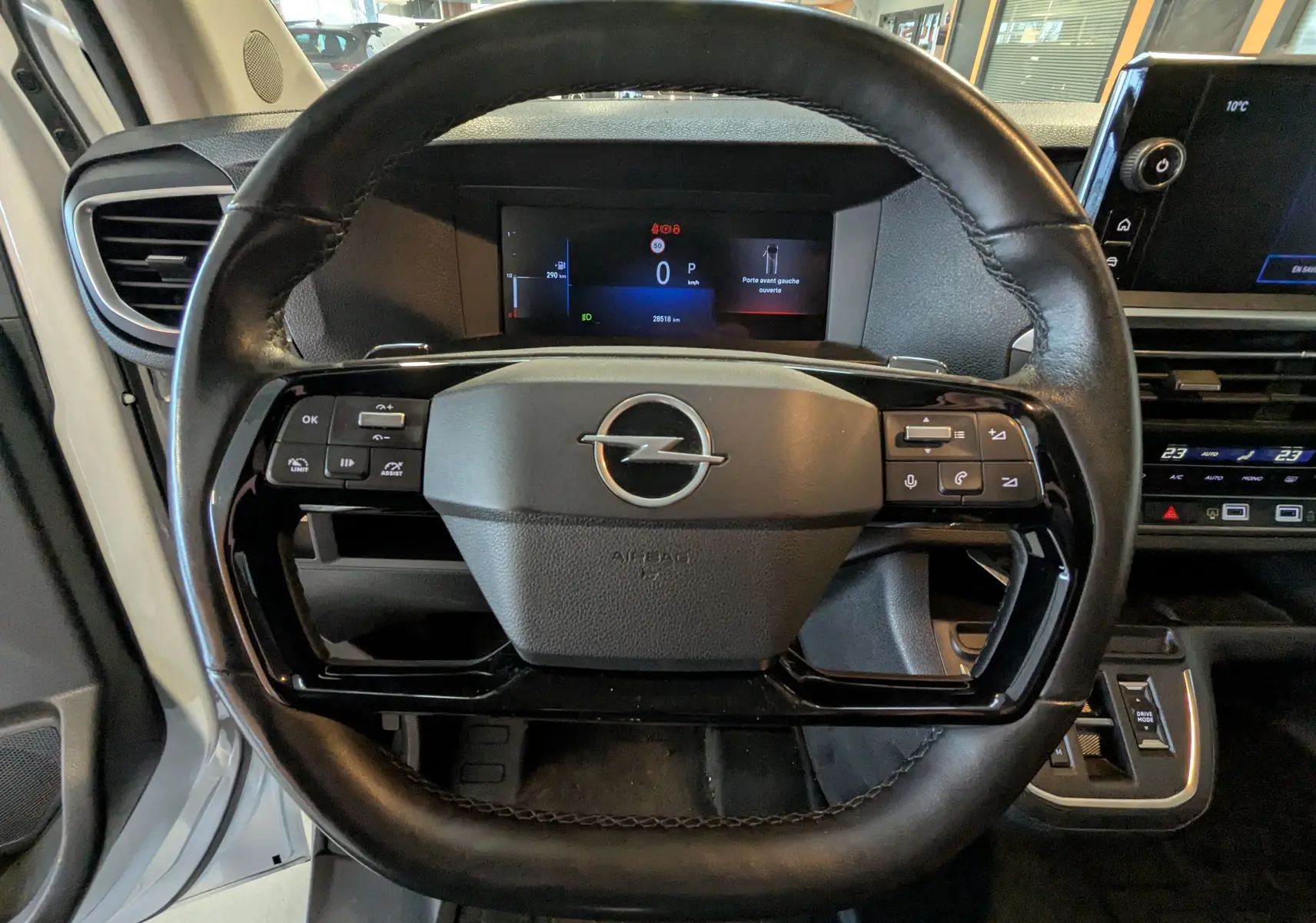 Vue intérieure centrée sur le volant noir de l'Opel Vivaro Fourgon XL 2024 avec tableau de bord digital et commandes intégrées.